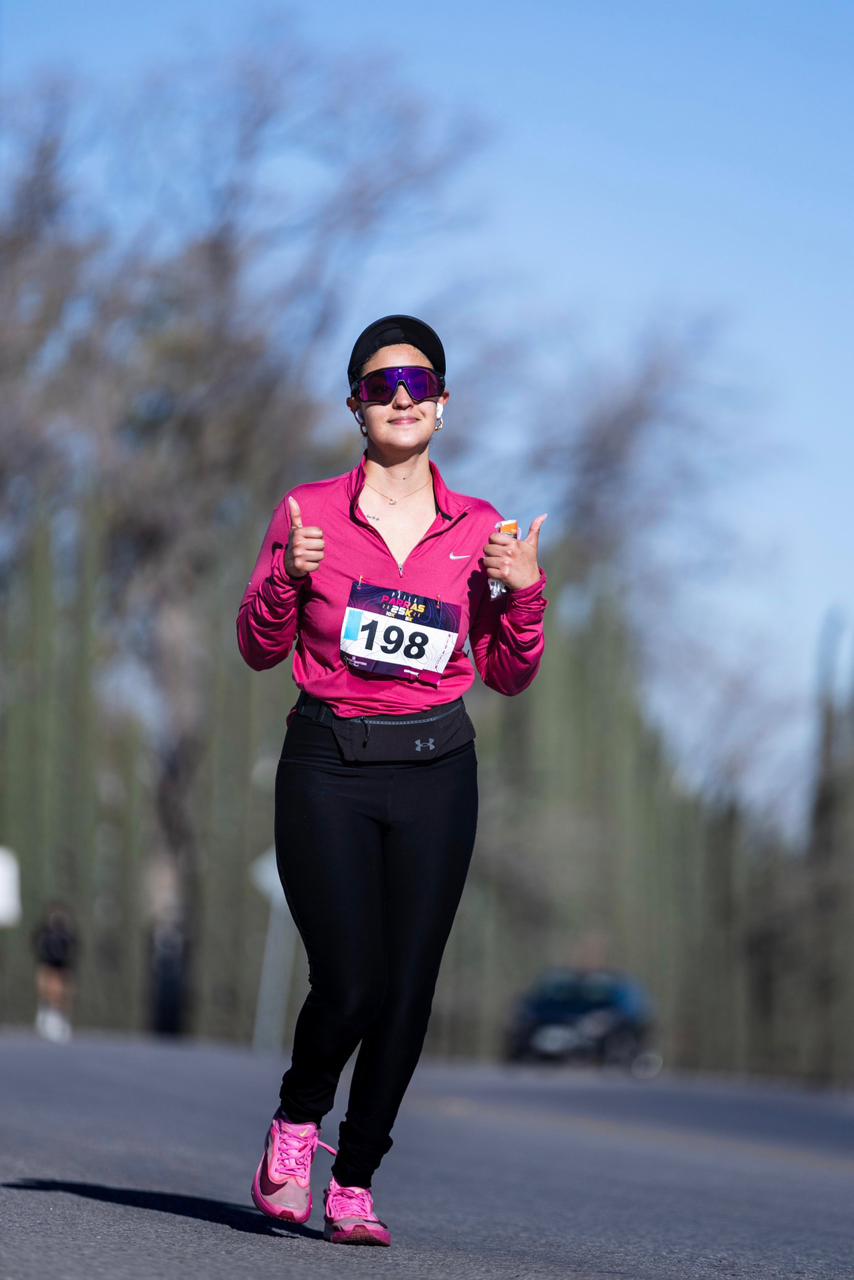 Mujer combina su outfit con lentes running racsol modelo aura color purpura negro rojo rosa. nike after dark tour 2026.